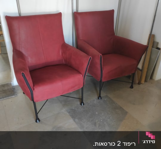 שני כורסאות מרופדות באדום עם רגלי מתכת שחורות
